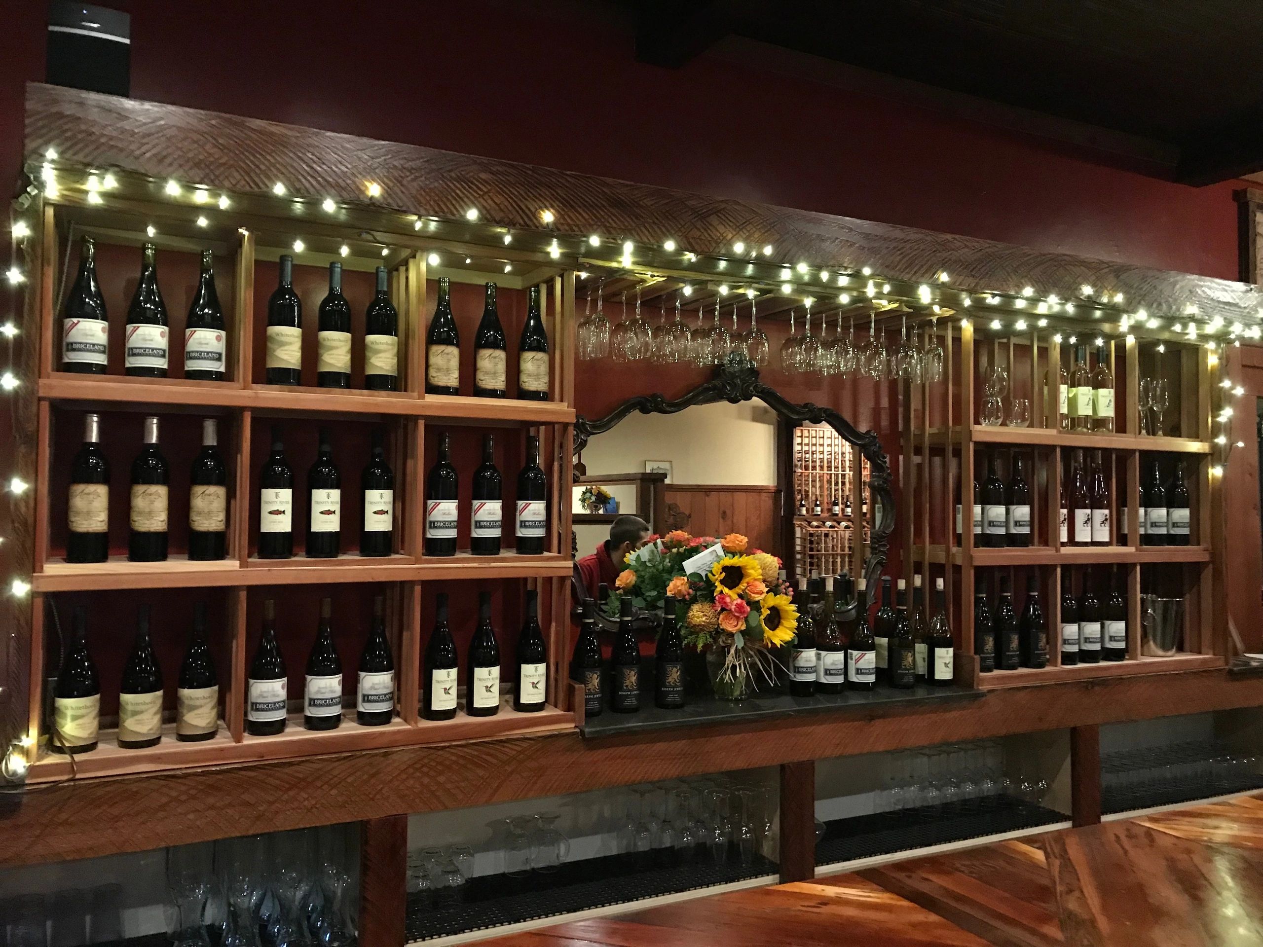 Wine bar display with shelving and red wall